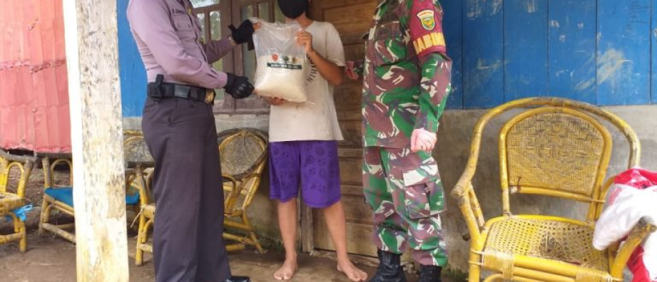 Babhinkamtibmas dan Babinsa yang membantu dalam penyaluran beras